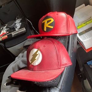 Two snap back superhero hats. One Robin and one the flash